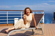 © rubchikova - Happy woman sits on a chair on the open deck of a cruise liner