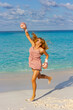 © rubchikova - Happy girl on the beach in a pink boxing gloves