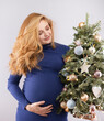 © rubchikova - Pregnant woman with a decorated christmas tree