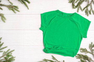 Wall Mural - Green t-shirt mockup with copy space, Christmas Holiday template flatlay. Top view blank t-shirt on white background. Happy New Year decorations