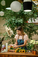 Wall Mural - Florist woman making a bouquet of fresh flowers in a flower shop