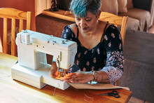 Woman With One Hand Working On A Sewing Machine