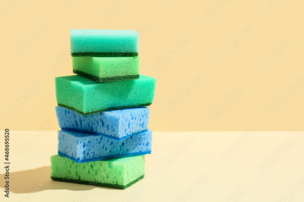Different cleaning sponges on color background