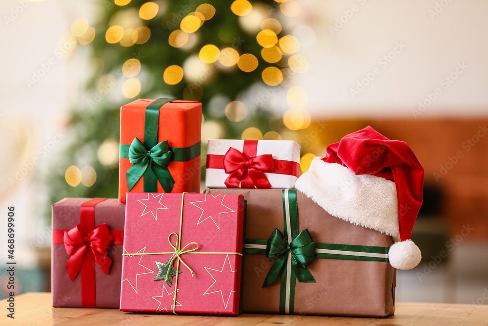 Christmas gifts with Santa hat on table in room