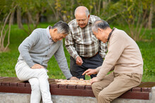Cheerful Senior Men Playing Chinese Chess