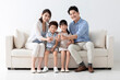 © Blue Jean Images - Cheerful young family sitting on sofa
