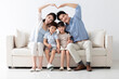 © Blue Jean Images - Cheerful young family sitting on sofa