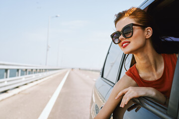 Wall Mural - a woman is driving in a car on the road and looking out of the window