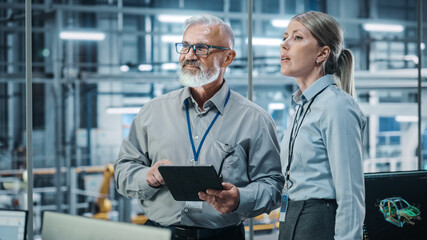 Poster - Car Factory: Female Project Manager Talks to Male Automotive Engineer, Plan Strategy Using Tablet Computer. Automated Robot Arm Assembly Line Production Conveyor Manufacturing Electric Vehicles 