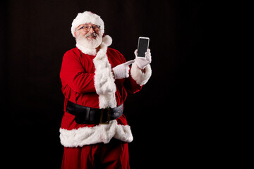 Santa Claus using a mobile phone on black background