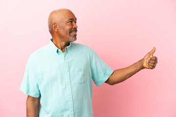 Wall Mural - Cuban senior isolated on pink background giving a thumbs up gesture