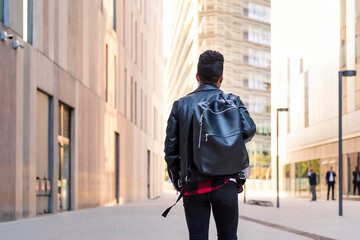 rear view of a stylish student walking in the city