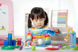 © M-image - young girl playing color sorting and fine motor skill toy at home
