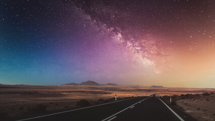 Canvas Print - Beautiful view of the empty road with the Milky Way in the background.