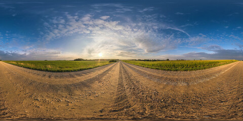 Wall Mural - spherical hdri 360 panorama on gravel road among fields in summer evening sunset with awesome clouds in seamless equirectangular projection, ready for VR AR virtual reality