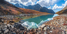 Amazing Clean Mountain Lake In A High-altitude Valley. Beautiful Nature Of Altai Mountains. Lake In The Valley, Rocks And Snow. Wonderful Summer Sunny Day With Gorgeous Cloudscape.