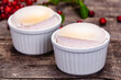 Souffle with cranberries in white ramekin on wooden rustic table. Close up