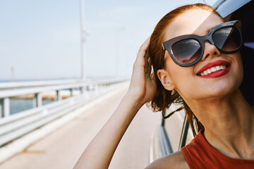 Wall Mural - cheerful woman peeking out of the car window trip adventure lifestyle