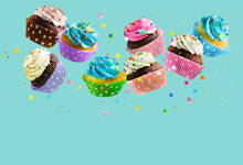 Cupcakes With Colorful Sprinkles Falling Over Aqua Blue Background. Copy Space