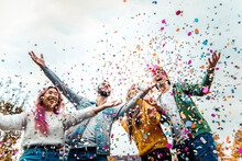 Happy Friends Celebrating Throwing Confetti In The Air - Young People Having Outdoor Party - Students Having Fun Together At College Campus - Youth Culture Concept