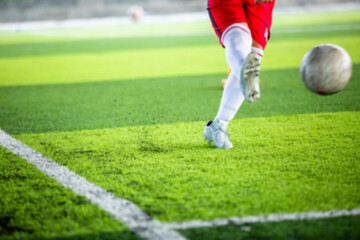 Wall Mural - Blurry picture of soccer player shoot football.