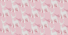 Creative Pastel Pink Winter Pattern Made With White Reindeer Ornaments On Pink Background. Trendy Christmas Composition.