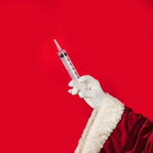 Santa Claus Offers A Vaccine Injection. Christmas Celebration During Coronavirus Pandemic, Grotesque Concept.