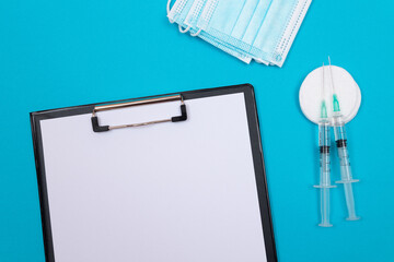 vaccination, immunology or revaccination concept - two medical syringe lying on blue table in doctor