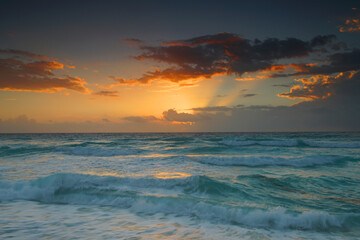 Wall Mural - sunrise with light from behind the cloud and reflection in the ocean