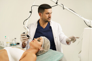 Poster - Doctor dermatologist and woman client during laser skin resurfacing treatment