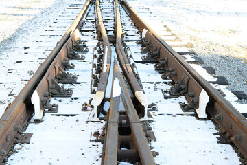 Image of an empty winter railroad track. Crossing railway tracks. Narrow gauge railway.