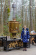Little girl standing near huge traditional metal russian tea samovar