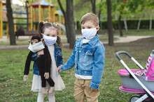 Child Boy And Girl Walking Outdoors With Face Mask Protection. Little Girl Holds A Stuffed Monkey In Her Hands. Coronavirus, Covid-19
