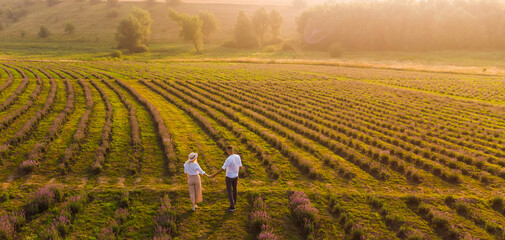 Wall Mural - Beautiful happy couple on purple lavender field, having fun on floral glade, summer nature, love concept