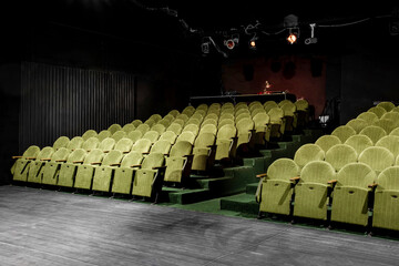 small auditorium with green armchairs