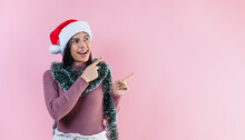 Portrait Of Young Latin Woman With Copy Space In A Christmas Concept On Pink Background	