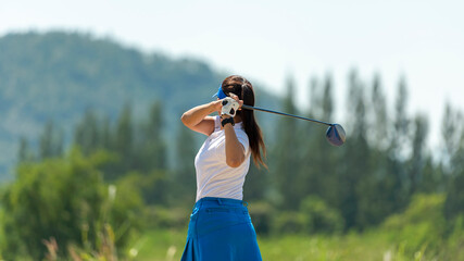 Wall Mural - Golfer sport course golf ball fairway. People lifestyle woman playing game golf tee of mountain background. Asia female player game shot in summer. Healthy and Sport outdoor