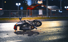 Motorcycle Lying On Asphalt After An Road Accident. Moto Bike Collision At Night. Damaged Motorcycle Lay On Asphalt Road