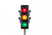 Isolated Traffic Light Showing An Illuminated Red, Amber And, Green Light.  Concept Image Illustrating Control Of The COVID Pandemic And Confusion With Movement Between Levels.

