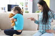 Mom shows a finger at a daughter, a girl with a toy