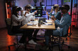 © Sofiia Shunkina - Group of four multiracial colleagues wearing VR headset during working meeting at office. Business partners sitting at desk and touching virtual screen.
