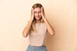 © luismolinero - Blonde Uruguayan girl isolated on beige background with headache