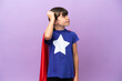 © luismolinero - Little kid isolated on purple background in superhero costume and having doubts