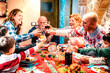 Large happy family having fun at christmas supper party - New years eve and winter holiday concept with parents and children eating together at home toasting wine and juices - Focus on glasses