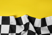 Checkered Finish Flag On Yellow Background, Top View. Space For Text