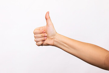 Wall Mural - Female hand showing the thumb up gesture isolated on a white background. Positive hand sign. Finger up