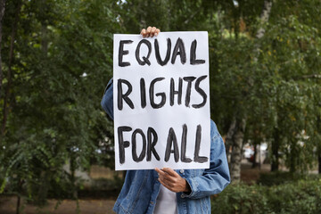 Woman holding sign with text Equal rights for all outdoors