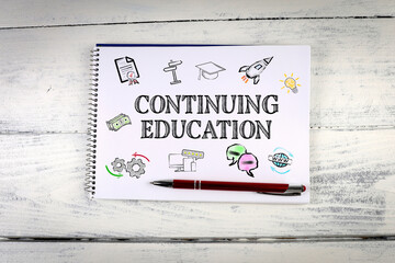 Wall Mural - Continuing Education, Business Concept. Notebook on a white wooden table