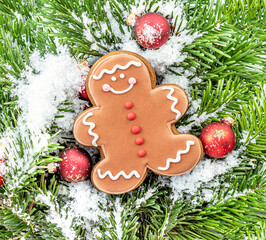 Wall Mural - christmas background with gingerbread man, fir branches and decorations as a background. .