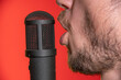 © Danny_Houston87 - Singing Male Mouth In Front Of A Microphone On A Red Background. Broadcast, Radio and Podcasts. Singing Songs and Recording into the Microphone.